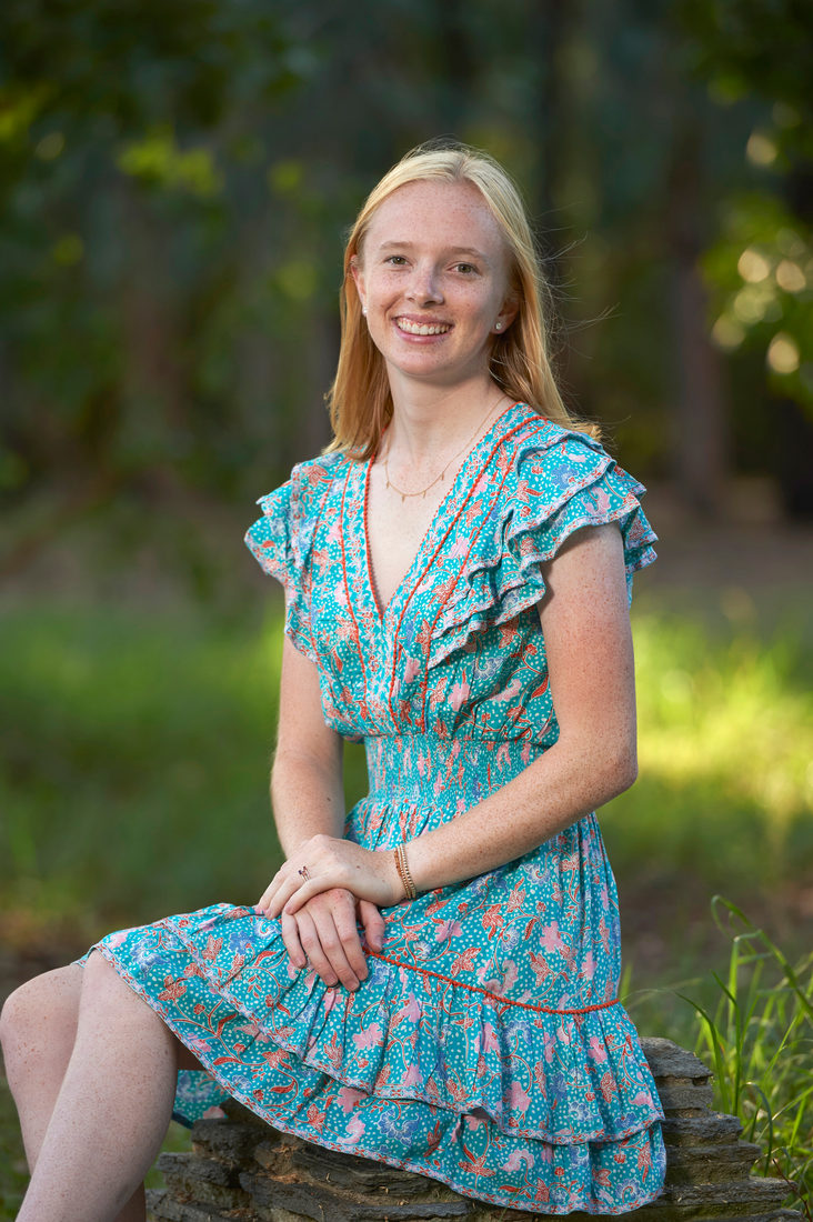 Maggie, smiling, seated outdoors